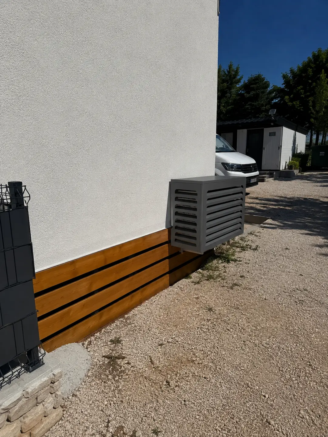 A Matro enclosure concealing a condenser at the base of a rendered wall